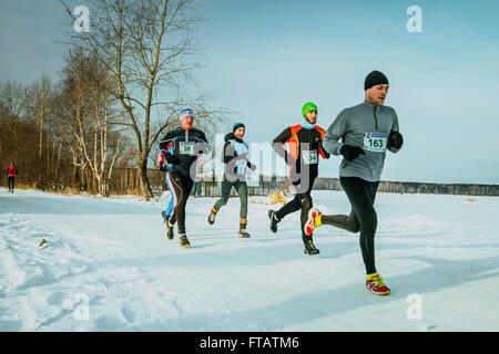 Jekaterinburg, Russland - 14. November 2015: Gruppe Athleten Männer und Mädchen laufen entlang Ufer Lake mit Schnee bedeckt, während marathon Stockfoto