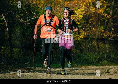 entlang einer alten Mann und junge Frau im herbstlichen Wald beim Bergmarathon Stockfoto