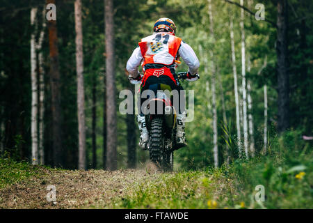 Motorradfahrer fährt entlang der Straße, Rückansicht während "Ural Cup Enduro" Stockfoto