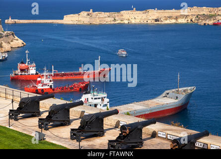 Die Ansicht des Grand Harbour mit Ankern Frachtschiffe und salutieren Batterie aus der Upper Barrakka Gardens, Valletta, Malta Stockfoto