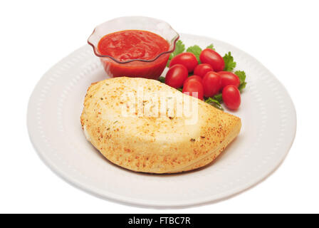 Vergoldete Calzone mit Tomaten Dip Sauce & frische Tomaten Stockfoto