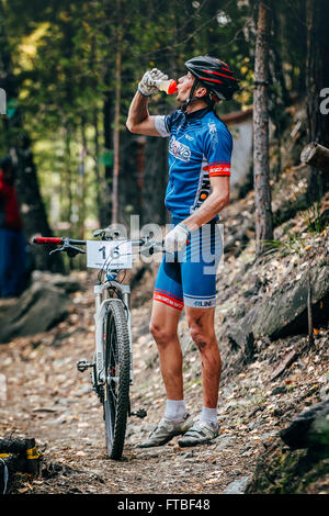 Sludorudnik, Russland - 13. September 2015: Racer Biker in Wäldern Sportgetränk aus Flasche zu trinken, während Blagikh Racing Cup Stockfoto