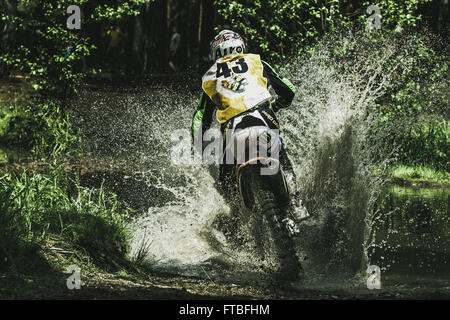 Motocross-Fahrer unter Wasserstrahl konkurriert Ural Cup Enduro Rennen Stockfoto