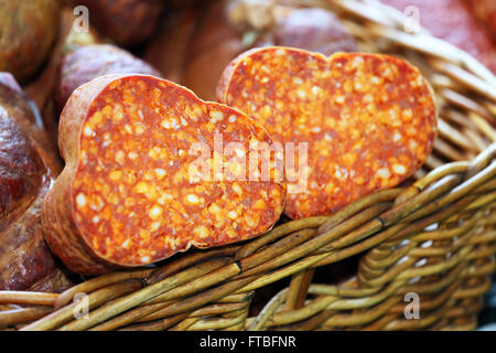 Hausgemachte ungarische Salami halbieren in Korb zum Verkauf Stockfoto