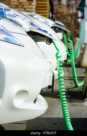 Kristianstad, Schweden - 20. März 2016: Die Aufladung von einigen weißen Nissan elektrische Autos. Grüne Kabel aufgerollt hängen an th Stockfoto