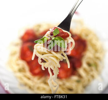 Spaghetti Nudeln mit Fleischbällchen und Tomatensauce auf weißem Hintergrund Stockfoto