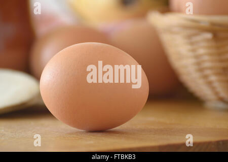 Ein Ei auf einem Holztisch in einer rustikalen Küche. Hautnah. Stockfoto