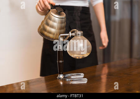 Nahaufnahme von Frau mit Siphon Kaffeemaschine und Topf Stockfoto