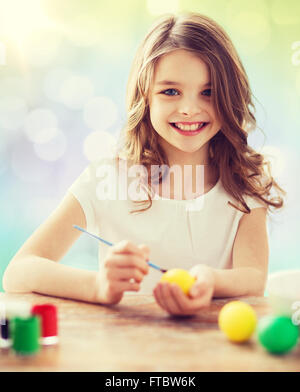 glückliches Mädchen mit Pinsel Ostereier färben Stockfoto