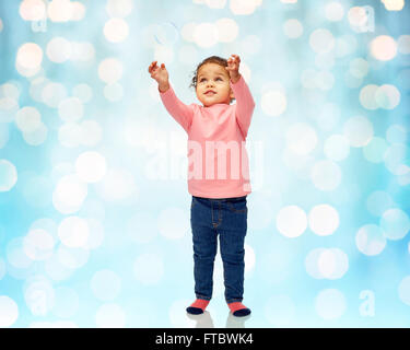 kleines Mädchen spielt mit Seifenblasen Stockfoto