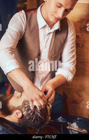 Professionelle Friseur Waschen eines bärtigen Mannes Haupt Stockfoto