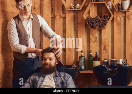 Positiven Friseur Haar seines Mandanten mit Handtuch trocknen Stockfoto