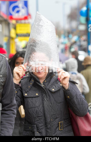 Putney, London, UK. 27. März 2016. Fußgänger in Putney High Street sind gefangen in ein nach unten gießen gebracht im Sturm Katie auf Ostern Sunda Kredit: Amer Ghazzal/Alamy Live-Nachrichten Stockfoto