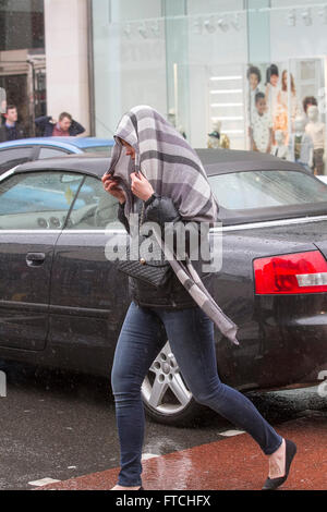 Putney, London, UK. 27. März 2016. Fußgänger in Putney High Street sind gefangen in ein nach unten gießen gebracht im Sturm Katie auf Ostern Sunda Kredit: Amer Ghazzal/Alamy Live-Nachrichten Stockfoto