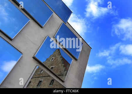 Das historische Gebäude "Ebracher Hof" spiegelt sich in der zeitgenössischen Windows das Hauptzollamt in Schweinfurt, Deutschland, 26. März 2016. Foto: KARL-JOSEF HILDENBRAND/dpa Stockfoto