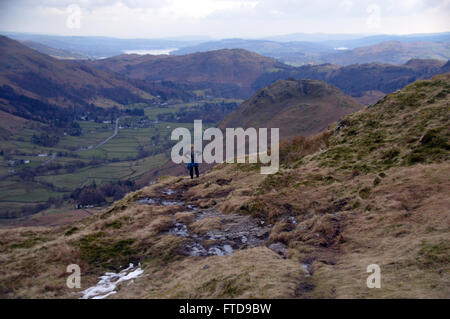 Dame mit den Händen auf den Hüften auf der Suche nach unten the Grasmere Tal nahe dem Gipfel des Stahl fiel, Cumbria. VEREINIGTES KÖNIGREICH. Stockfoto