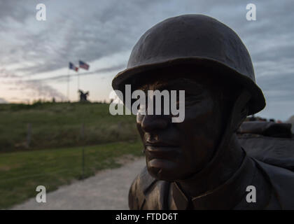 150605-N-QY759-452 UTAH BEACH, Frankreich (5. Juni 2015) Diese Bronzestatue ist Bestandteil der Higgins-Boot Denkmal auf Utah Beach, im Hintergrund ist das Denkmal der US Navy in Europa. Higgins-Boot-Denkmal gedenkt das Landing Craft Fahrzeug Personal, auch bekannt als "Higgins Boote," ihre Besatzungen und Boot-Designer Andrew Jackson Higgins. Das Denkmal wurde 6. Juni 2015 nach fast einem Jahr der Geldbeschaffung durch die Stadt Columbus, Nebraska gewidmet. Columbus ist die Heimatstadt von Higgins, wer entwarf die Landungsboote und dessen Firma 20.000 Wasserfahrzeuge für das US-Militär während Worl gebaut Stockfoto