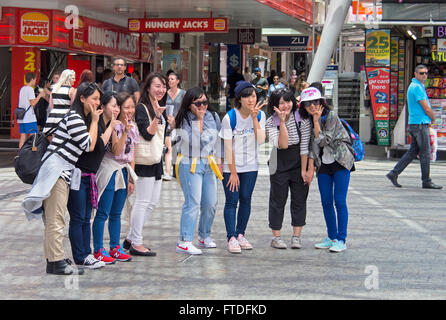 Chinesische Touristen posieren für ein Foto in Queen Street Mall, Brisbane, Australien Stockfoto