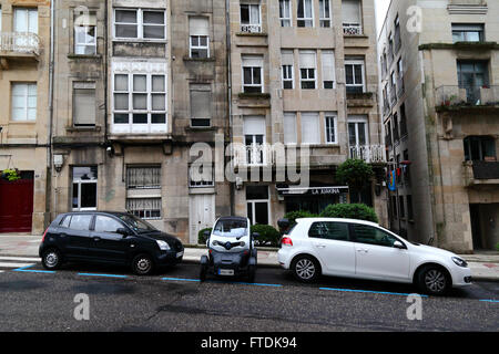 Renault Twizy Vierrad-Kleinwagen geparkt seitwärts zwischen 2 normalen Autos in der Straße, Vigo, Galicien, Spanien Stockfoto