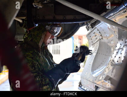 Ein Student der US Navy Aviation Structural Mechanic Airman ist gezeigt, wie er ein P-3C Orion Marine Patrouillenflugzeug auf der Naval Air Station Sigonella, Sizilien, als Teil des Wartungsplans zur Korrosionsvermeidung für das Flugzeug wäscht. Stockfoto