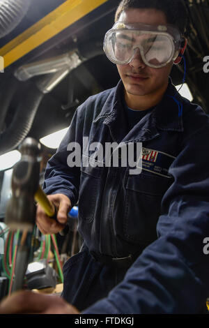 160123-N-FP878-069 Mittelmeer (23. Januar 2016) Gasturbine Systeme Techniker (mechanischen) 3. Klasse Andy Rodriguez, aus Tampa Bay, Florida, stanzt Löcher in eine neue Dichtung an Bord USS Carney (DDG-64) 23. Januar 2016. Carney, ein Zerstörer der Arleigh-Burke-Klasse geführte Flugkörper, vorwärts bereitgestellt, Rota, Spanien, ist die Durchführung einer Routine-Patrouille in den US 6. Flotte Bereich der Maßnahmen zur Erhöhung der Sicherheit der Vereinigten Staaten in Europa interessiert. (Foto: U.S. Navy Mass Communication Specialist 1. Klasse Theron J. Godbold/freigegeben) Stockfoto