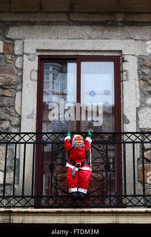 Aufblasbare Figur des Weihnachtsmanns hängen vom Balkon des typischen Steingebäude, Vigo, Galizien, Spanien Stockfoto