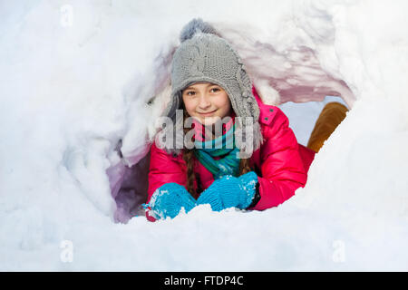 Mädchen ist im Tunnel draußen spielen, die sie von Schnee gegraben Stockfoto