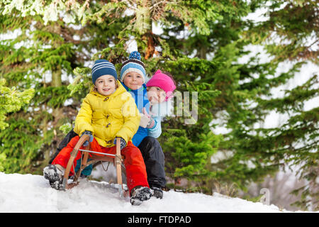 Kinder kleine Jungen und Mädchen auf Schlitten schieben Stockfoto