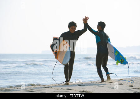 Japanische Surfer am Strand Stockfoto