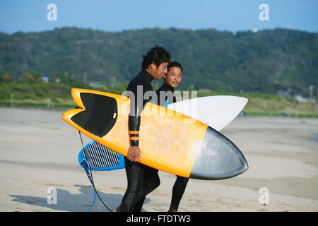 Japanische Surfer am Strand Stockfoto