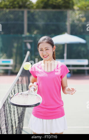 Junge japanische Tennisspielerin auf dem Platz Stockfoto