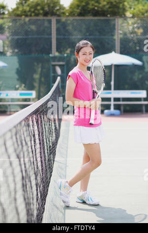 Junge japanische Tennisspielerin auf dem Platz Stockfoto
