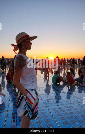 Weibliche beobachten Sonnenuntergang in Zadar. Grüße an Sonne Denkmal. Stockfoto