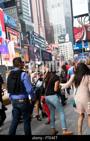 Rot bestrumpften Dame informiert die Menschen wo Rabatt Broadway VVK an den Ständen im nahe gelegenen Duffy Square Tickets. Stockfoto