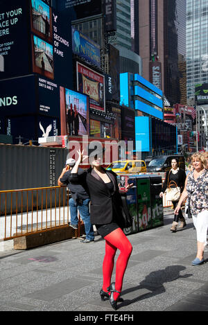 Rot bestrumpften Dame informiert die Menschen wo Rabatt Broadway VVK an den Ständen im nahe gelegenen Duffy Square Tickets. Stockfoto