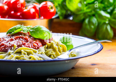 Nudeln. Italienische und mediterrane Küche. Nudeln Fettuccine mit Tomaten Sauce Basilikum Blätter Knoblauch und Parmesan-Käse. Stockfoto