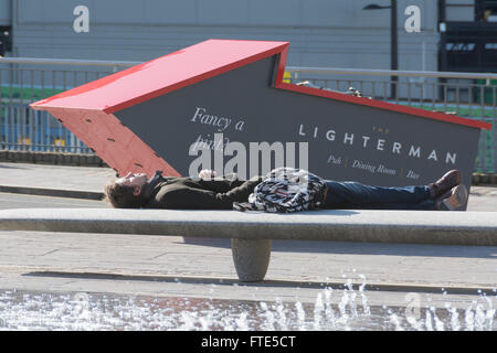 Mann schläft in Granary Square in Kings Cross in London. Stockfoto