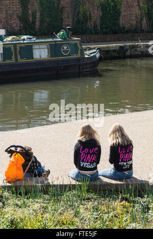 "Love Pink" Zwillingsschwestern sitzen neben Regent es Canal in der Londoner King Cross Granary Square Entwicklung Stockfoto