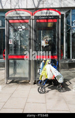 Rentner, Telefonieren in einer Telefonzelle auf der Londoner Euston Road, UK Stockfoto