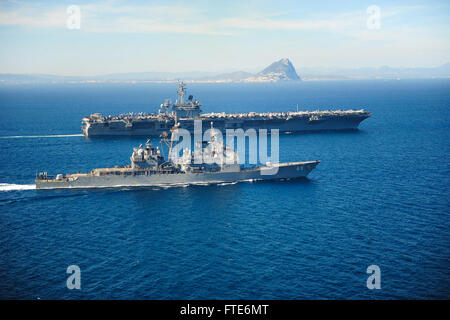 Die USS Vicksburg (CG 69), ein Lenkraketenkreuzer der Ticonderoga-Klasse, eskortiert die USS Theodore Roosevelt (CVN 71), einen Flugzeugträger der Nimitz-Klasse, durch die Straße von Gibraltar. Diese Operation ist Teil eines Einsatzes zur Unterstützung der US-Sicherheitsinteressen in Europa. Stockfoto