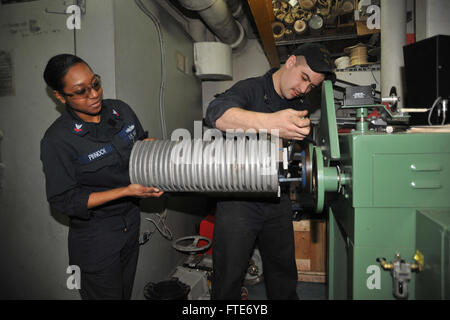 140222-N-IK431-030-Atlantik (22. Februar 2014) – Elektriker 3.Klasse Kaleb Cannon und Elektriker Mate Mate 2. Klasse Nicole Pinnock passen Sie den Kopf auf eine Wicklung Maschine an Bord der USS Bataan (LHD-5). Bataan amphibische Bereitschaft Gruppe wird bereitgestellt, Sicherheit im Seeverkehr Operationen zu unterstützen, die Krisenreaktionsfähigkeit, Theater Sicherheitskooperation und eine nach vorne Marine Präsenz in der US-Marine 5. und 6. Flotte Zuständigkeitsbereich erhöhen. (US Navy Foto von Massenkommunikation Spezialist Seemann Lehrling Aaron T. Kiser/freigegeben) Stockfoto