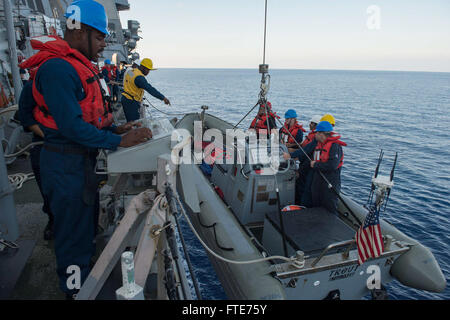 Dieses Bild zeigt Boatswains Mate 2nd Class Ikenna Osondu, der Seaman Jeremiah Bennett bei der Absenkung eines starren Schlauchbootes von der USS Ramage (DDG 61) leitet. Der Zerstörer der Arleigh-Burke-Klasse wird im Mittelmeer eingesetzt, um Sicherheitseinsätze zu unterstützen. Stockfoto