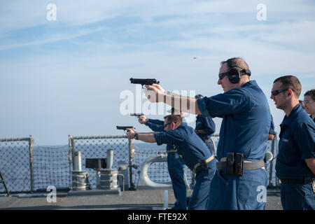 Mittelmeer (7. Januar 2014) - Feuer von vorne nach hinten, CMdR Robert Alpigini, Kommandierender Offizier der Arleigh-Burke-Klasse geführte Flugkörper Zerstörer USS Stout (DDG-55), Command Master Chief Albert Marcucci und CMdR Andrew Fitzpatrick, Geschäftsführer des Schiffes, 9 mm Pistolen während einer Kleinwaffen-Qualifikation.  Stout, Gridley in Norfolk, Virginia, ist auf eine geplante Bereitstellung unterstützen maritimer Sicherheitsoperationen und Sicherheitsbemühungen Zusammenarbeit Theater in den USA 6. Flotte Einsatzgebiet. (Foto: U.S. Navy Mass Communication Specialist 2. Klasse Amanda R. Gray/freigegeben) Stockfoto