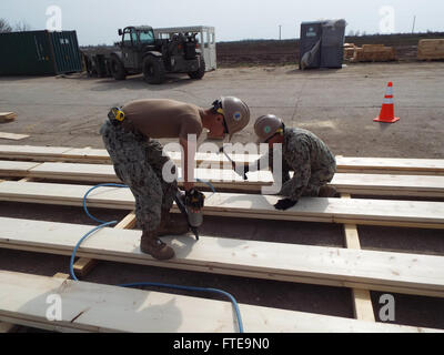 140326-N-ZZ999-063 DEVESELU AIR BASE, Rumänien (26. März 2014) - Builder 3. Klasse Nathan Dvorak und Equipment Operator Constructionman Henry McKissick, befestigt, Naval Mobile Bau-Bataillon 74 Detail Rumänien fabrizieren Träger. (Foto: U.S. Navy Utilitiesman Constructionman Sydney Thorne)  Nehmen Sie das Gespräch auf Twitter (https://twitter.com/naveur navaf) folgen Sie uns auf Facebook (https://www.facebook.com/USNavalForcesEuropeAfrica) und wenn du schon dabei bist uns auf Google + (https://plus.google.com/101085806745039159791/posts#101085806745039159791/posts Besuche) Stockfoto