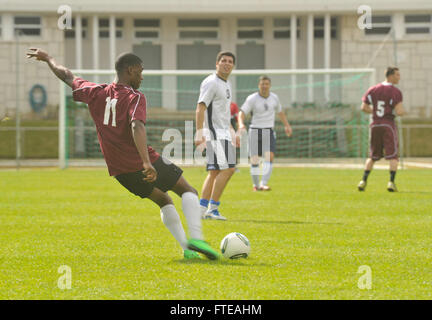 140228-N-AO823-052-Lissabon, Portugal (28. Februar 2014)--Lance Cpl. Lerome Harvey, aus New York, geht der Ball bei einem freundlichen Fußballspiel zwischen Mitgliedern der portugiesischen Marine und USS Bataan (LHD-5). Bataan amphibische Bereitschaft Gruppe wird bereitgestellt, Sicherheit im Seeverkehr Operationen zu unterstützen, die Krisenreaktionsfähigkeit, Theater Sicherheitskooperation und eine nach vorne Marine Präsenz in der US-Marine 5. und 6. Flotte Zuständigkeitsbereich erhöhen. (U.S. Navy Photo by Massenkommunikation Spezialist Seemann Lehrling Michael J. Lieberknecht / veröffentlicht) Stockfoto