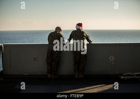 Dieses Foto zeigt Lieutenant Commander. John Carter, ein Truppenkaplan, führte ein Gespräch mit Petty Officer 3rd Class David Trebil, einem Krankenhauskommandanten an Bord der USS New York am Weihnachtstag 2014. Das Schiff war Teil der 24th Marine Expeditionary Unit im Gebiet der 6th Fleet. Stockfoto