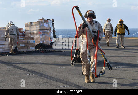 140312-N-HO612-005 Mittelmeer (12. März 2014) A Marine von Bekämpfung Cargo trägt Ausrüstung für vertikale Auffüllungen mit USNS Robert E. Peary (T-AKE-5) auf dem Mehrzweck amphibischer Angriff Schiff USS Bataan (LHD-5) März 12. Die Bataan amphibische Bereitschaft Gruppe ist auf eine geplante Bereitstellung unterstützen maritimer Sicherheitsoperationen Absicherung Krise Antwort Fähigkeit und Theater Kooperationen in den USA 6. Flotte Einsatzgebiet. (U.S. Navy Photo by Massenkommunikation Spezialist 3. Klasse Erik Foster/freigegeben) Stockfoto