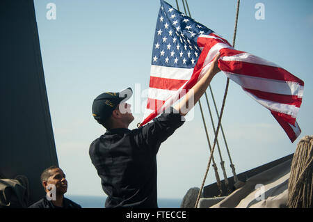 140319-N-WD757-080-Mittelmeer (19. März 2014) – ruft Quartiermeister Seemann Kevin Hopkins ein nationaler Ensign geflogen in Hingabe, ein ehemaliger Chief Petty Officer, die an Bord der geführte Flugkörper-Zerstörer USS Arleigh Burke (DDG-51) serviert. Arleigh Burke ist auf eine geplante Bereitstellung zur Unterstützung der Sicherheit im Seeverkehr Operationen und Sicherheitsbemühungen Zusammenarbeit Theater in den USA 6. Flotte Einsatzgebiet. (Foto: U.S. Navy Mass Communication Specialist 2. Klasse Carlos M. Vazquez II/freigegeben)  Nehmen Sie das Gespräch auf Twitter (https://twitter.com/naveur navaf) folgen Sie uns auf Facebook Stockfoto