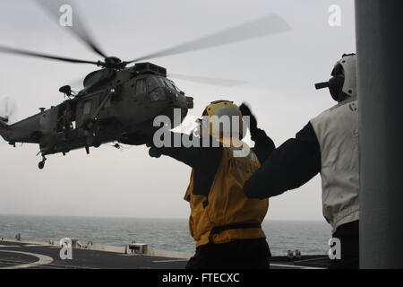 140331-N-ZZ999-025 an Bord USS LEYTE GULF, auf hoher See (31. März 2014)--US Navy Petty Officer 2. Klasse Stuart McCollum, Landing Signal meldete an Bord der geführte Flugkörper Kreuzer USS Leyte Gulf (CG-55), einen britische königliche Marine SH-3 Sea King Hubschrauber von HMS Illustrious im Flugbetrieb Montag landet.  Golf von Leyte läuft zur Teilnahme an gemeinsamen Krieger 14-1, eine halbjährliche, Großbritannien führte Trainingsübung NATO und Alliierten bieten ein einzigartiges Multi-Kriegsführung-Umfeld, um für globale Einsätze vorzubereiten.  Die gemeinsame Ausübung der Krieger soll Integration verbessern Stockfoto