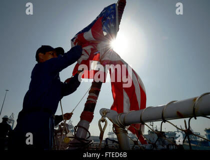 Der Logistikspezialist der 3. Klasse Frederick Beltran an Bord der USS Ramage (DDG 61) hebt das nationale Fähnrich während der Abfahrt des Schiffes aus Haifa, Israel. Die USS Ramage führt Operationen im Einsatzgebiet der 6. US-Flotte durch, was zur maritimen Sicherheit und zur Zusammenarbeit im Theater beiträgt. Stockfoto
